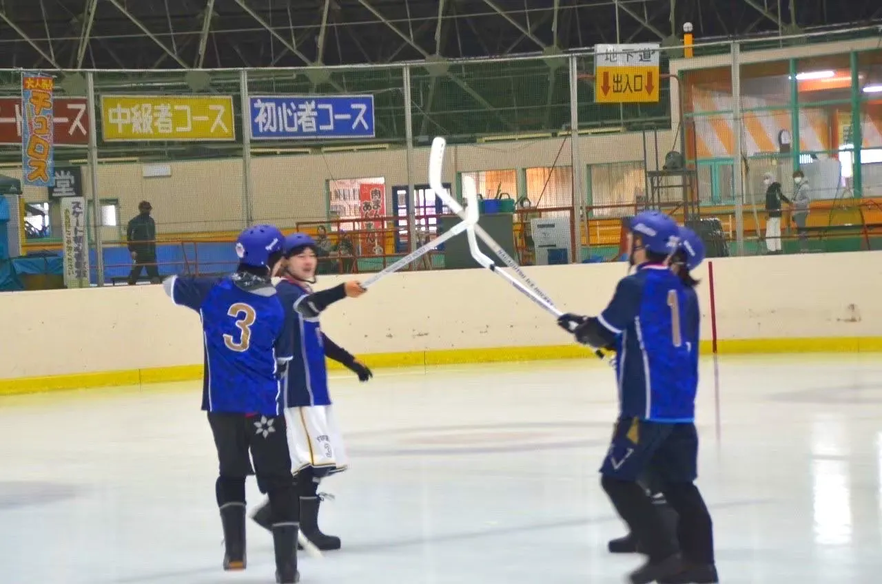試合の後、リンクの上でハイタッチする同じチームの選手たち
